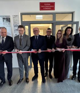 Symbolicznego przecięcia wstęgi dokonuje siedem osób - od lewej: Członek Zarządu Województwa Łódzkiego Artur Ostrowski, II Wicewojewoda Łódzki Grzegorz Majewski, I Wicewojewoda Łódzki Marek Mazur, Burmistrz Drzewicy Janusz Reszelewski, p.o. Zastępcy Dyrektora Wojewódzkiego Urzędu Pracy w Łodzi Aneta Dziemdziela, Przewodnicząca Rady Miejskiej w Drzewicy Dorota Wiktorowicz oraz p.o. Zastępcy Dyrektora Regionalnego Centrum Polityki Społecznej w Łodzi Oskar Kuliński.