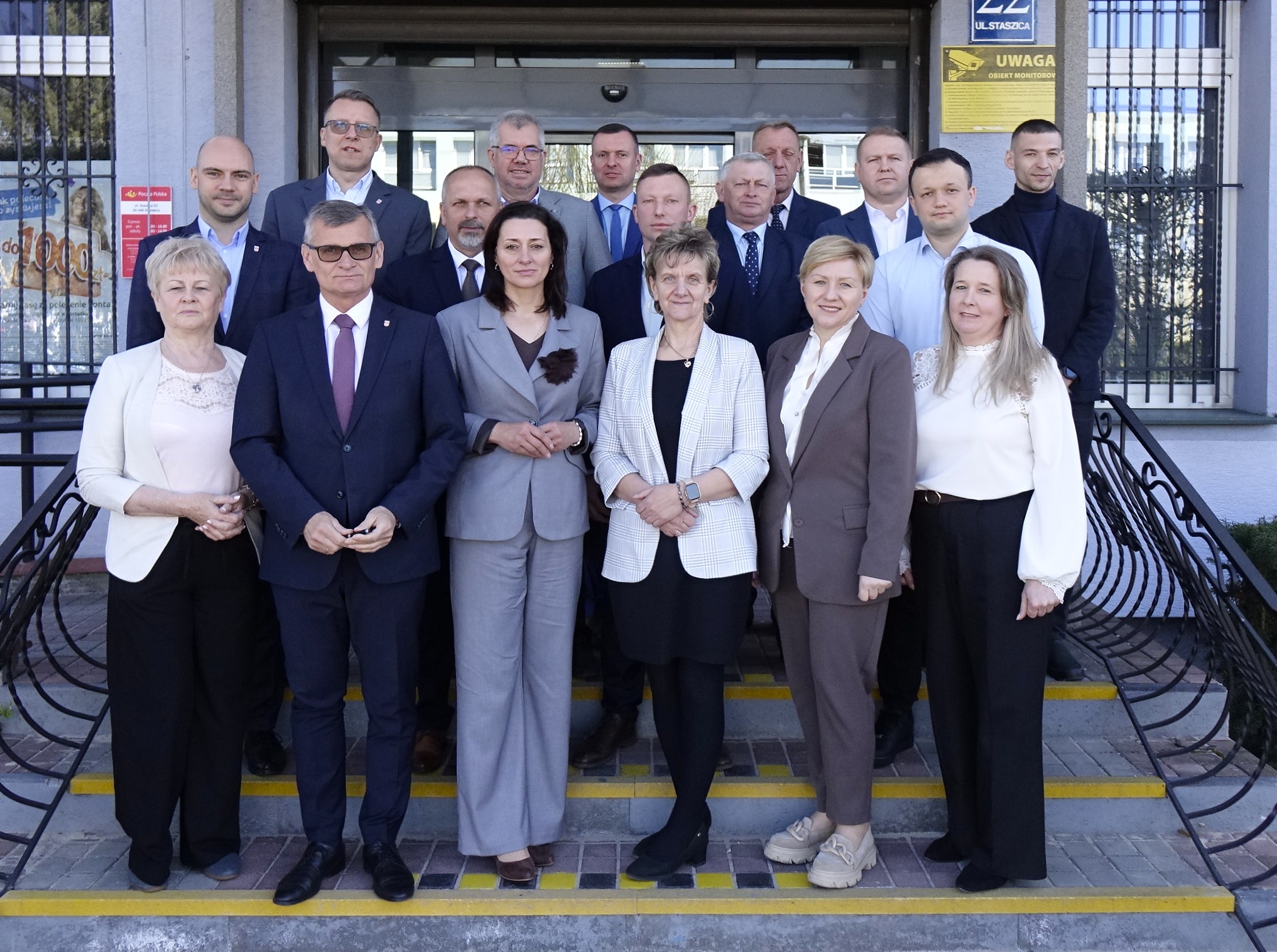 Przed budynkiem Urzędu Miejskiego w Drzewicy grupowe zdjęcie radnych rady miejskiej z burmistrzami