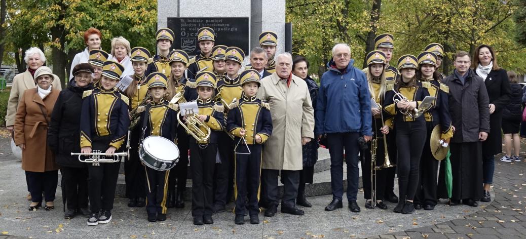 Pamiątkowa fotografia uczestników uroczystości przy Pomniku Pamięci w parku na placu Wolności