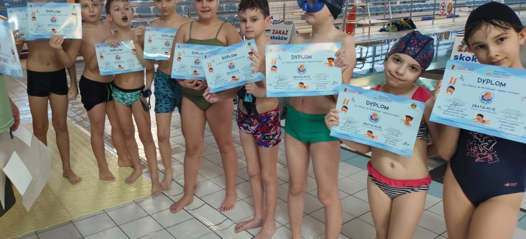 Grupa uczniów SP w Drzewicy trzymających dyplomy za udział w programie „Umiem pływać”