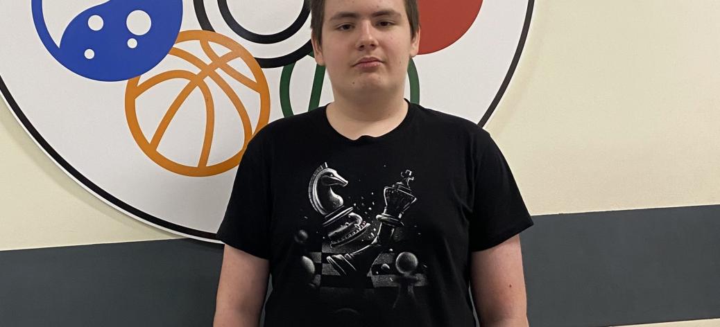 Sergiusz Stuleblak stoi na tle logo SP w Drzewicy
