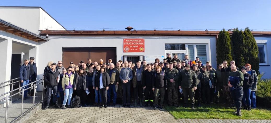 Kilkudziesięcioosobowa grupa uczestników akcji stoi przed budynkiem świetlicy wiejskiej – strażnicy OSP w Jelni.