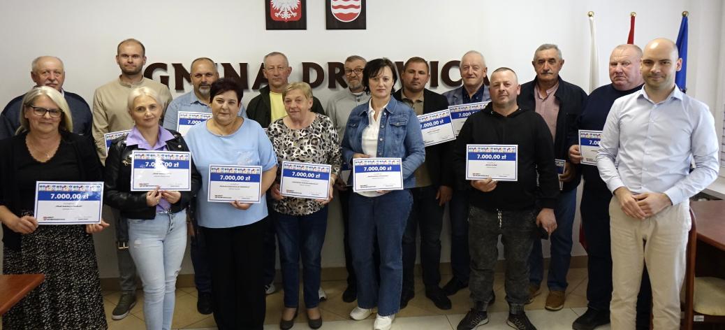 Grupowe zdjęcie autorów projektów obywatelskich z Zastępcą Burmistrza Drzewicy Dominikiem Niemirskim. Kilkanaście osób stoi w sali konferencyjnej UM w Drzewicy