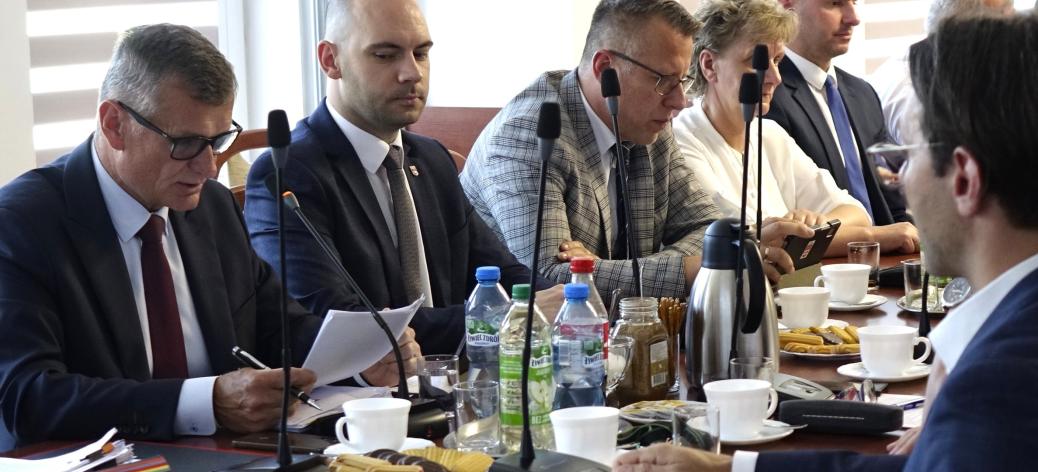 Siedząc przy stole uczestnicy sesji słuchają sprawozdania międzysesyjnego Burmistrza Drzewicy Janusza Reszelewskiego