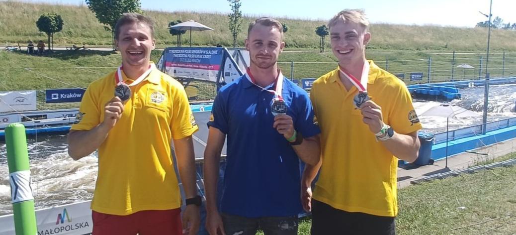Na tle toru slalomowego stoją prezentując srebrne medale - od lewej Szymon Zawadzki, Michał Franczak i Maciej Bartos