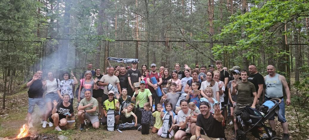 Pamiątkowe zdjęcie kilkudziesięcioosobowej grupy piechurów na terenie za Domkiem Myśliwskim