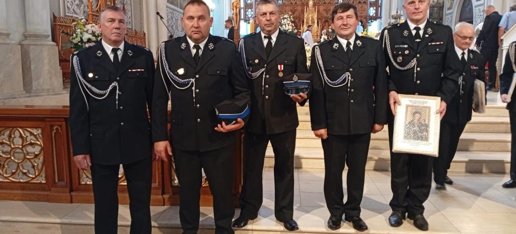 We wnętrzu radomskiej katedry stoi pięciu ubranych w galowe mundury strażaków OSP. Pierwszy z prawej trzyma obraz Matki Bożej
