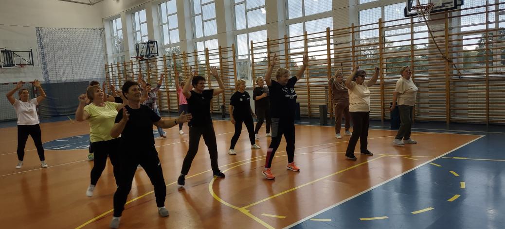 Grupa seniorów na zajęciach fitness w hali sportowej SP w Radzicach Dużych.