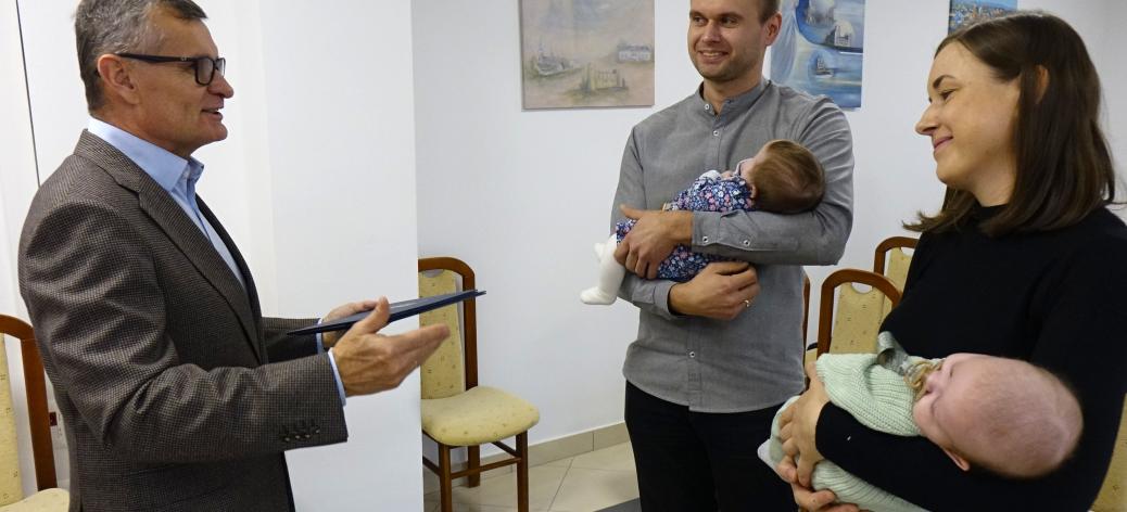 Burmistrz Drzewicy Janusz Reszelewski gratuluje rodzicom bliźniąt – Annie i Mariuszowi Skrętowskim, którzy trzymają bobasy na rękach.
