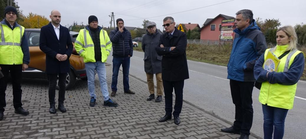 Uczestnicy odbioru – osiem osób, w tym Burmistrz Drzewicy Janusz Reszelewski i Zastępca Burmistrza Dominik Niemirski – stoją przy przebudowanej drodze powiatowej w Krzczonowie