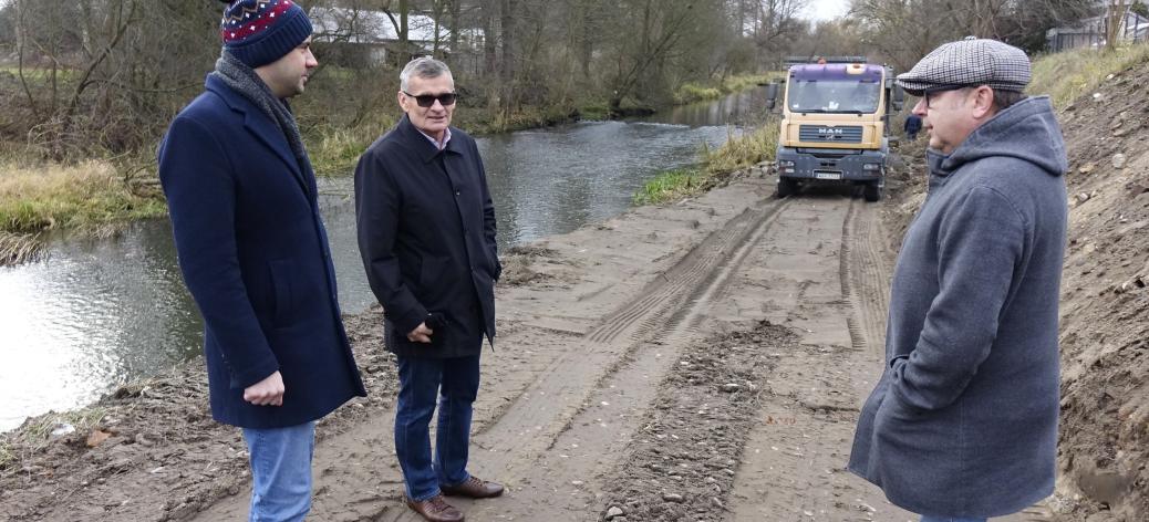 Na gruntowej drodze przy brzegu Drzewiczki stoją od lewej Zastępca Burmistrza Drzewicy Dominik Niemirski, Burmistrz Janusz Reszelewski, Kierownik Ref. Inwestycji UM Jarosław Bomba