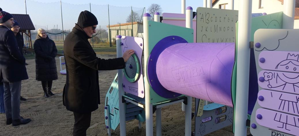 Burmistrz Drzewicy stoi przy urządzeniu wielofunkcyjnym. Obok pozostali uczestnicy odbioru.