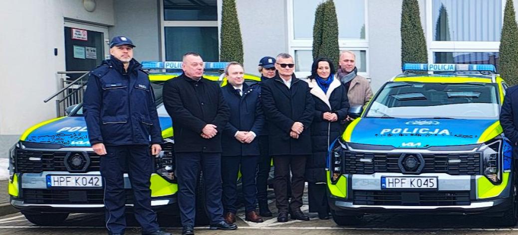 Na parkingu przed siedzibą KPP w Opocznie między dwoma radiowozami stoi siedem osób - dwoje policjantów i pięcioro samorządowców , w tym Burmistrz Drzewicy i Przewodnicząca Rady Miejskiej w Drzewicy