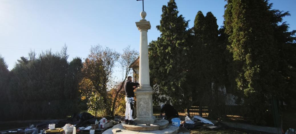 Prace montażowe przy odrestaurowanej kamiennej przydrożnej Kolumnie Toskańskiej z wieńczącym ją krzyżem. 