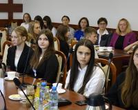 Uczestnicy sesji siedzą przy stołach w sali konferencyjnej Urzędu Miejskiego w Drzewicy. W centrum zdjęcia młodzieżowe radne, z tyłu m.in. nauczycielki