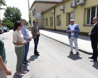 Uczestnicy odbioru (sześć osób) stoją na przebudowanej drodze przy budynku byłego dworca PKP w Drzewicy