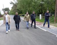  Pięciu uczestników odbioru idzie przebudowaną drogą i ciągiem pieszym na ulicy Słowackiego w Drzewicy