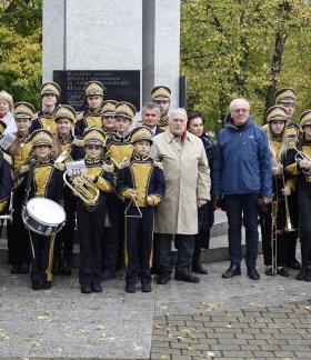 Pamiątkowa fotografia uczestników uroczystości przy Pomniku Pamięci w parku na placu Wolności