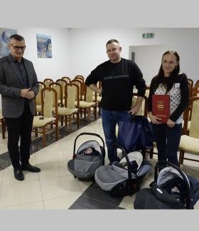  Burmistrz Drzewicy Janusz Reszelewski i rodzice trojaczków z chłopcami leżącymi w nosidełkach