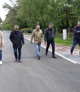 Pięciu uczestników odbioru idzie przebudowaną drogą i ciągiem pieszym na ulicy Słowackiego w Drzewicy