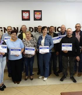  Grupowe zdjęcie autorów projektów obywatelskich z Zastępcą Burmistrza Drzewicy Dominikiem Niemirskim. Kilkanaście osób stoi w sali konferencyjnej UM w Drzewicy