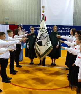 Ośmioro uczniów – przedstawicieli poszczególnych klas – ślubuje na sztandar szkoły. W środku poczet sztandarowy