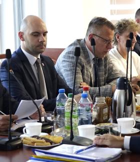 Siedząc przy stole uczestnicy sesji słuchają sprawozdania międzysesyjnego Burmistrza Drzewicy Janusza Reszelewskiego