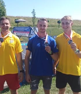 Na tle toru slalomowego stoją prezentując srebrne medale - od lewej Szymon Zawadzki, Michał Franczak i Maciej Bartos