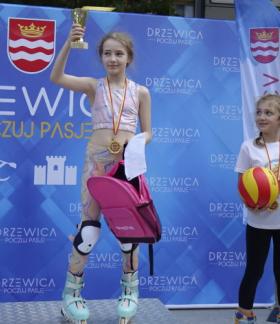 Podium w kategorii wiekowej 7-9 lat. W tle błękitna ścianka promocyjna Gminy Drzewica. Od lewej Lena Pyzik, Zuzanna Kotaniec, Nadia Pyzik oraz Zastępca Burmistrza Drzewicy Dominik Niemirski