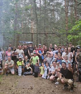 Pamiątkowe zdjęcie kilkudziesięcioosobowej grupy piechurów na terenie za Domkiem Myśliwskim