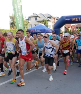 Na ulicy Staszica obok budynku Urzędu Miejskiego w Drzewicy grupa biegaczy rozpoczyna bieg główny na 5 km