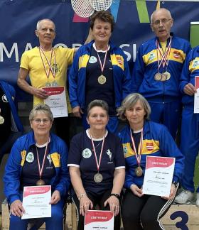 Na podium stoją i siedzą ubrani w żółto-niebieskie dresy reprezentanci UTW w Drzewicy - osiem osób z medalami i dyplomami