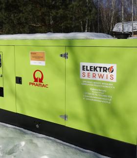 Agregat prądotwórczy o mocy 80 kW w kolorze jasnej zieleni, stojący na zewnątrz w zimowej scenerii