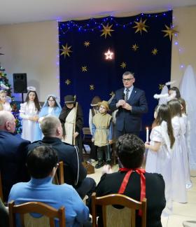 Świetlica Wiejska w Radzicach Dużych. Na tle występujących dzieci z SP w Radzicach przemawia do zgromadzonych Burmistrz Drzewicy Janusz Reszelewski. 