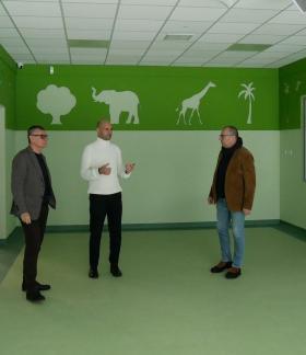 Pomalowane w odcieniach zieleni pomieszczenie bawialni oglądają od lewej: Burmistrz Drzewicy Janusz Reszelewski, Zastępca Burmistrza Dominik Niemirski oraz Kierownik Referatu Gospodarki Komunalnej, Budownictwa i Inwestycji Urzędu Miejskiego w Drzewicy