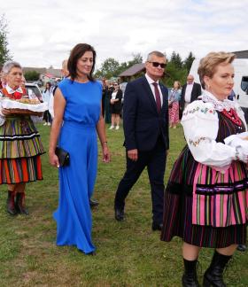  Korowód dożynkowy idący po trawie – na czele osoby w strojach ludowych z chlebami oraz przedstawiciele władz Gminy Drzewica. 