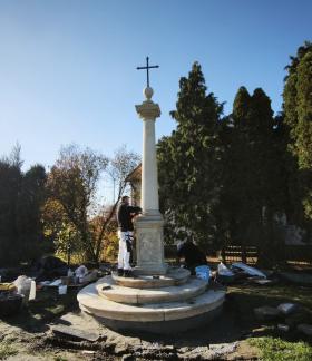 Prace montażowe przy odrestaurowanej kamiennej przydrożnej Kolumnie Toskańskiej z wieńczącym ją krzyżem. 