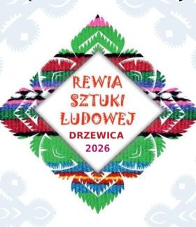 Logo imprezy pn. Rewia Sztuki Ludowej „Drzewica 2026” umieszczone na tle białego wzoru i tradycyjnego, barwnego haftu. 