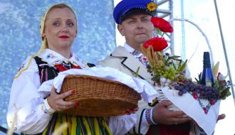 Na scenie dożynkowi starostowie - Marta Jakubczyk z wiklinowym koszem i Daniel Dąbrowski z płodami rolnymi