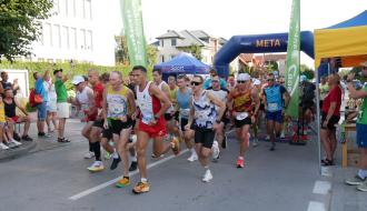 Na ulicy Staszica obok budynku Urzędu Miejskiego w Drzewicy grupa biegaczy rozpoczyna bieg główny na 5 km