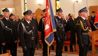 Strażacy OSP Radzice stojący ze sztandarem wewnątrz kościoła podczas mszy świętej.