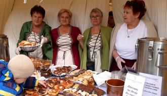 Gospodynie z KGM Drzewiczanki w średniowiecznych strojach prezentują wyroby i ciasta na stoisku gastronomicznym