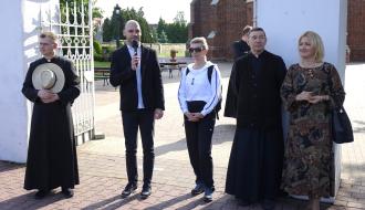 Przy bramie kościelnej stoją od lewej: ks. Michał Kopciński, Zastępca Burmistrza Drzewicy Dominik Niemirski (z mikrofonem), Dyrektor SP w Drzewicy Agnieszka Bogatek, drzewicki proboszcz - ks. kan. Adam Płuciennik, Dyrektor SP w Radzicach Małgorzata Wawrzyńczak-Pawul