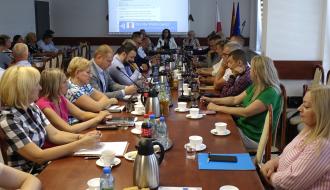 Uczestnicy sesji siedzą przy stołach w sali konferencyjnej Urzędu Miejskiego w Drzewicy.