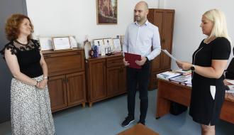 Kameralna uroczystość w gabinecie Wiceburmistrza Drzewicy. Po lewej stroi Renata Wilk, w środku Zastępca Burmistrza Drzewicy Dominik Niemirski, po prawej Dyrektor ZEAS Agnieszka Kwiecień, która odczytuje rotę ślubowania nauczyciela mianowanego