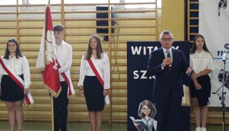 Uroczysta inauguracja roku szkolnego w SP w Drzewicy. Głos zabiera Burmistrz Drzewicy Janusz Reszelewski. Po lewej poczet sztandarowy
