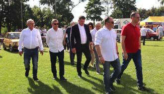 Podczas pikniku Remtraka po płycie boiska Stadionu Miejskiego w Drzewicy idą – od lewej: I Wicewojewoda Łódzki Marek Mazur, Burmistrz Drzewicy Janusz Reszelewski, Członek Zarządu Województwa Łódzkiego Artur Bagieński, Wójt Sławna Tadeusz Wojciechowski, Członek Zarządu PKP Intercity Remtrak Michał Franas i Minister Infrastruktury Dariusz Klimczak