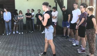 Kilkunastoosobowa grupa uczestników projektu podczas warsztatów edukacyjnych przy budynku ośrodka wypoczynkowego