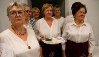 Siedem członkiń KGM „Drzewiczanki”. Stojąca w środku gospodyni trzyma tacę z opłatkami. 