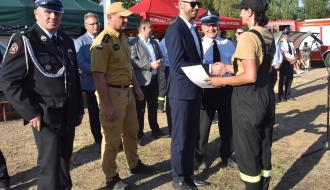  Ceremonia dekoracji kobiecej drużyny OSP Żardki. Zastępca Burmistrza Drzewicy Dominik Niemirski gratuluje druhnie Dorocie Wiktorowicz